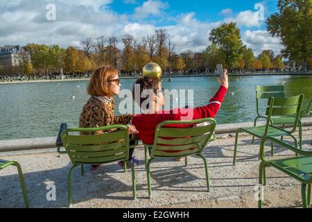 Francia Paris Les Tuileries turista giovane fotografa se stessi in background sfera dorata artwork da James Lee Byars durante FIAC 2013 Foto Stock