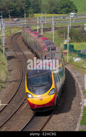 Westmorland, Shap, Regno Unito 19 Giugno 2014. Vergine del treno Costa Ovest linea rinnovata di franchising. Viaggiare Virgin Pendolino e Voyager treni passeggeri a Shap, Cumbria, Regno Unito. Treni del Virgin e il Dipartimento per i trasporti hanno firmato un nuovo accordo garantendo notevoli miglioramenti sia per i passeggeri che per i contribuenti. Il nuovo West Coast franchise verrà eseguito fino al marzo 20171 e vedrà significativi miglioramenti per i clienti con l'introduzione del libero superfast WiFi, più sedi e nuovi servizi. Foto Stock