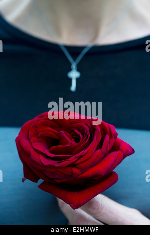 Donna che mantiene single rose, ritagliato Foto Stock