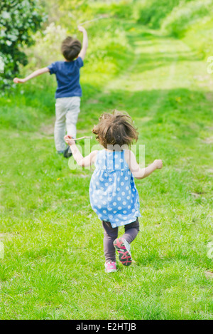 I bambini in esecuzione sul percorso attraverso la campagna Foto Stock