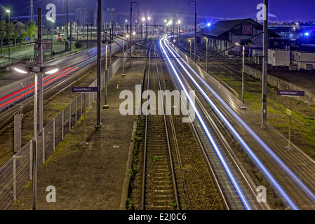 Una lunga esposizione di treni in movimento su ferrovia a notte, Gare de Chantenay, Nantes, Loire-Atlantique, Francia Foto Stock
