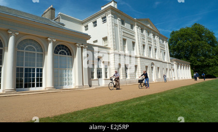 Una coppia senior (più vecchi ciclisti) persone che camminano con la bici oltre la parte anteriore del Kenwood House Hampstead Heath London NW3 UK KATHY DEWITT Foto Stock