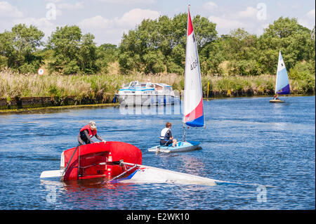 Norfolk, Regno Unito. Il 21 giugno, 2014. Thomas Mackinson età 10 dell'Beccles Amateur Sailing Club gode di una perfetta giornata d'estate praticando un capovolgimento su un Topper sul fiume Waveney su Norfolk Broads in Norfolk, Inghilterra, UK Credit: T.M.O.News/Alamy Live News Foto Stock