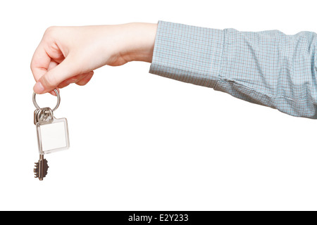 Vista laterale del grezzo di lavorazione per chiave che corona nella mano stretta fino isolato su sfondo bianco Foto Stock