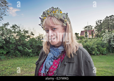 Selfportrait. Middleaged Donna con fiori nei capelli. Midsummernights capodanno in Svezia. Foto Stock