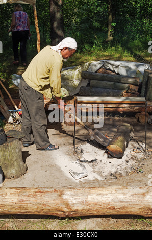 La cottura di alimenti da parte di turisti su un fuoco di legno. Foto Stock