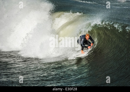 Florida surfer anatre sotto il labbro di beccheggio di una onda vicino alla Spiaggia di Jacksonville Pier. Stati Uniti d'America. Foto Stock