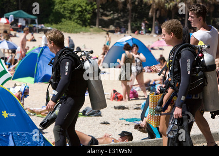 Due uomini preparando andare deep sea diving a piedi attraverso Manly Beach,Sydney , Australia Foto Stock