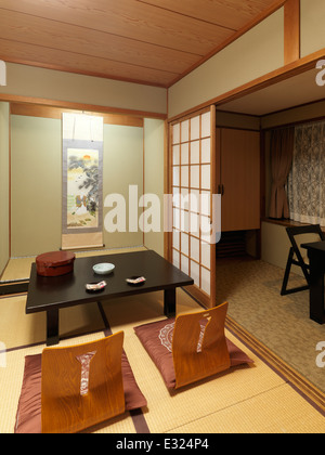 Chabudai tavolo da tè e zaisu sedie al tradizionale sala giapponese di un ryokan hotel a Kyoto, Giappone Foto Stock