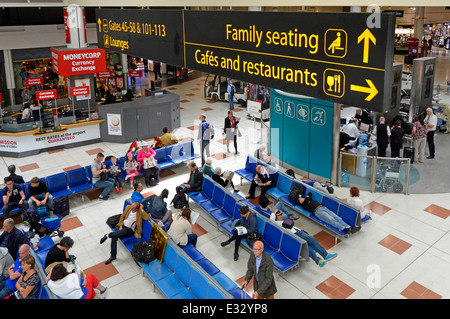 Guardando verso il basso l'area salotto per famiglie e i caffè, i ristoranti segnalano l'aeroporto di Londra Gatwick, il terminal nord, la sala partenze e l'atrio dello shopping, Inghilterra e Regno Unito Foto Stock