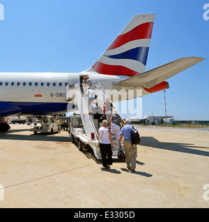 Imbarco passeggeri British Airways aereo tramite lo sportello di accesso posteriore avente stato collegato via bus fuori dal terminale per utilizzare scale mobili aeroporto di Roma Italia Foto Stock