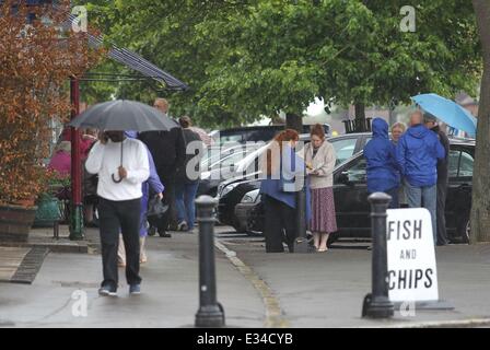 Wet Weather immagini formano Beaconsfield, Bucks. Persone sedersi sulle panche sotto gli ombrelloni, una sposa determinato ad avere una buona giornata, cattive condizioni stradali dotate di: persone che camminano nella High Street dove: Beaconsfield, Buckinghamshire, Regno Unito quando: 15 Ju Foto Stock