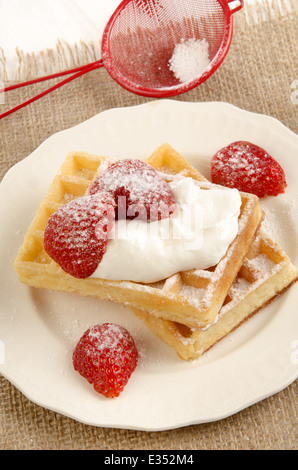Home waffle fatti con panna acida e fragole su una piastra Foto Stock