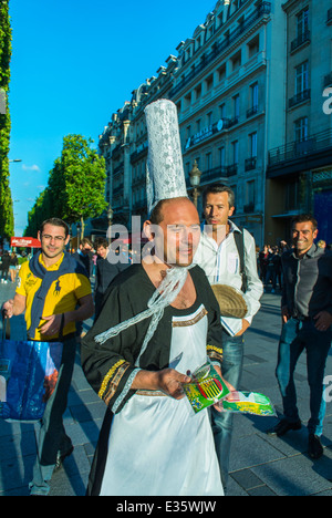 Parigi, Francia, uomo nel copricapo tradizionale delle donne della Bretagna, bigoudène (cofano alto), sull'Avenue Champs-Elysees, cross dresser Foto Stock