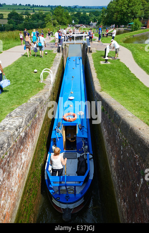 Blue canal narrowboat passando attraverso un blocco serrature Foxton Market Harborough LEICESTERSHIRE REGNO UNITO Foto Stock