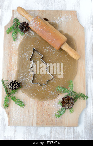 Composizione di natale di pasta di zenzero, mattarello e сhristmas ramoscelli di albero. Foto Stock