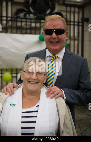 Belfast City Hall,UK. Il 22 giugno 2014. Celebrity Julian Simmons con un cancro Macmillan sostenitore al traguardo del 6 maratone in 6 Paesi in 6 giorni Foto Stock