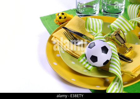 Soccer Football parte messa in tavola con pâté, posate, bicchieri, trofeo, pallone da calcio e decorazioni in giallo e verde, Foto Stock