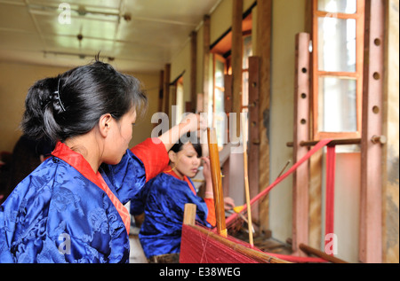 Ragazze imparando il mestiere di tessitura in Istituto Nazionale per i disabili e il centro di tessitura, Khaling, Est Bhutan Foto Stock