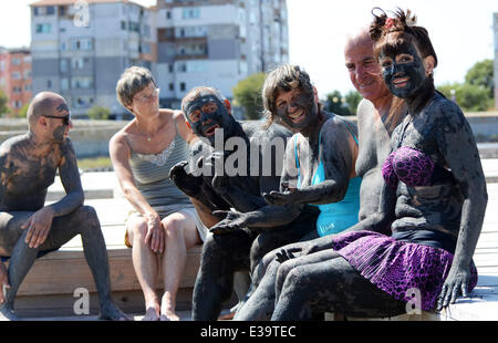 Persone cospargere di fango nero oltre i loro corpi come provano a curare i disturbi. Molti credono che il fango da un lago vicino al Mar Nero città Foto Stock