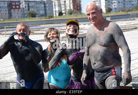 Persone cospargere di fango nero oltre i loro corpi come provano a curare i disturbi. Molti credono che il fango da un lago vicino al Mar Nero città Foto Stock