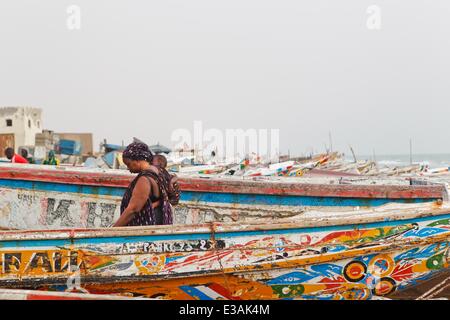 Nouakchott, Mauritania. Il 22 giugno, 2014. Una donna cammina attraverso le imbarcazioni al mercato del pesce a Nouakchott, capitale della Mauritania, 22 giugno 2014. © Li Jing/Xinhua/Alamy Live News Foto Stock