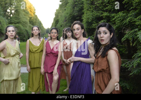 Old Westbury, New York, Stati Uniti d'America. Il 21 giugno, 2014. Lori Belilove & di Isadora Duncan Dance Company sono in attesa nel sud Allée, un ampio passaggio pedonale fiancheggiata da alberi sempreverdi, poco prima che la moderna ballerini eseguirà la notte di mezza estate evento finale al Long Island Gold Coast station wagon di Old Westbury Gardens il primo giorno di estate, il solstizio d'estate. La sig.ra Belilove indossa una tunica bianca con viola over-sciarpa. © Ann Parry/ZUMA filo/ZUMAPRESS.com/Alamy Live News Foto Stock