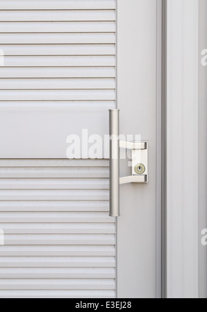 Pomello metallico sulla porta bianca Foto Stock