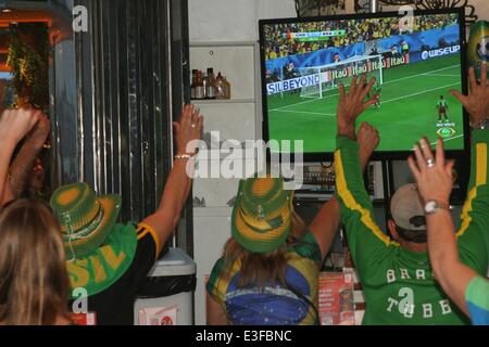 Rio de Janeiro, Brasile, 23 Giugno, 2014. 2014 FIFA World Cup Brasile. Tifosi brasiliani di celebrare il primo gol contro il Camerun in un chiosco sulla spiaggia di Copacabana Beach. Credito: Maria Adelaide Silva/Alamy Live News Foto Stock