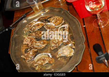 Ostriche su di una piastra e di vino bianco Foto Stock