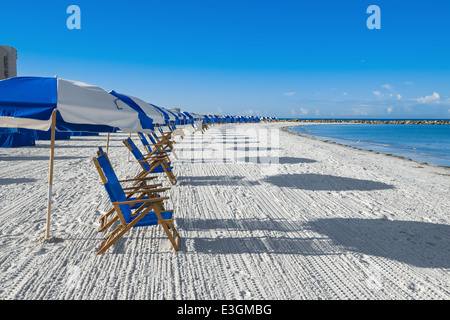 Un sacco di sedie a sdraio e ombrelloni da spiaggia in sabbia di argento, concetto di vacanza Foto Stock