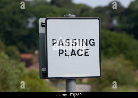 Strada rurale segno "passante posto'. Norfolk. East Anglia. In Inghilterra. Regno Unito. Affiancato a sezione di appositamente allargata strada stretta. Foto Stock