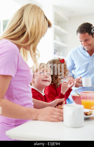 Famiglia con prima colazione in cucina prima della scuola Foto Stock