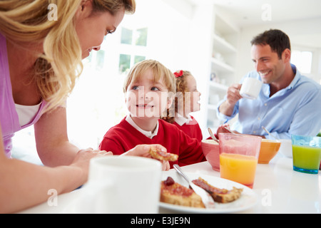 Famiglia con prima colazione in cucina prima della scuola Foto Stock