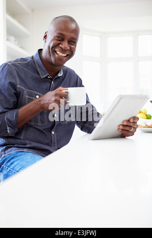 African American Uomo con tavoletta digitale in casa Foto Stock