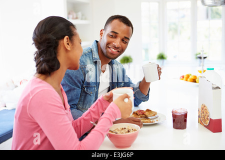Giovane avente la colazione nella cucina insieme Foto Stock