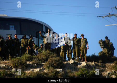 Hebron, West Bank, Territorio palestinese. Il 24 giugno 2014. Soldati israeliani cerca per tre ragazzi mancanti nella città di Halhul vicino al West Bank città di Hebron, Martedì 24 Giugno, 2014. Dal lancio del funzionamento, Israele ha trattenuto almeno 360 palestinesi, compresi 250 operatori di Hamas e 57 ex prigionieri liberati nel 2011. L esercito ha detto che anche hanno razziato 63 Hamas istituzioni civili. Gli arresti hanno avuto luogo diverse settimane prima del presunto rapimento dei giovani israeliani. Poiché il rapimento il 12 giugno, Israele ha arrotondato fino a decine di altri operatori di Hamas liberato nel 2011 prigioniero Foto Stock