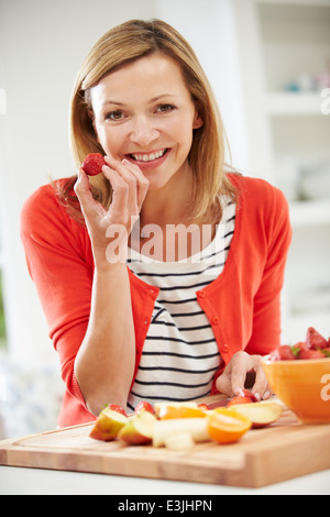La donna la preparazione di insalata di frutta in cucina Foto Stock