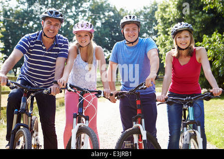 Famiglia con figli adolescenti sul tragitto in bicicletta in campagna Foto Stock