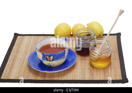 Tè con limone e miele nella tazza del tappetino Foto Stock