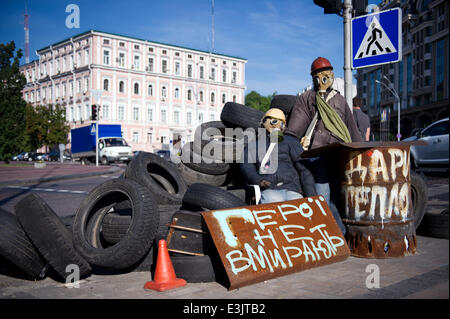 Kiev, Ucraina. Il 24 giugno 2014. Due marionette con maschere a gas a sedersi su una barricata fatta di pneumatici per auto su Maidan di Kiev, in Ucraina, 24 giugno 2014. Il tenace processo di disinnescare la crisi in Ucraina sembra essere lento di raccolta slancio. La pro-russo separatisti attualmente rispettare un cessate il fuoco chiamato dal governo ucraino. Foto: DANIEL NAUPOLD/DPA/Alamy Live News Foto Stock