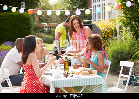 Gruppo di amici di barbecue all'aperto a casa Foto Stock