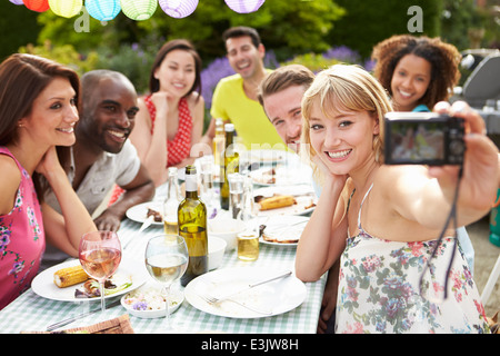 Amici prendendo Autoritratto sulla fotocamera al barbeque all'aperto Foto Stock