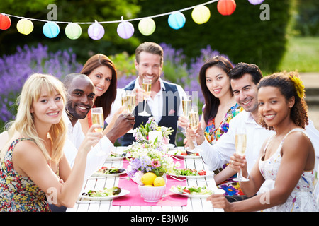 Gruppo di amici gustando Outdoor Dinner Party Foto Stock