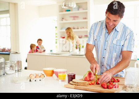 Padre di famiglia prepara la colazione in cucina Foto Stock