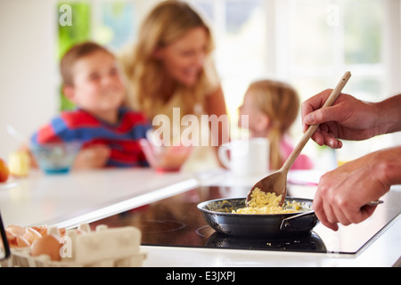 Chiusura del padre di famiglia prepara la colazione in cucina Foto Stock