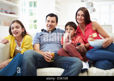 Famiglia di origine ispanica seduti sul divano guardando la TV insieme Foto Stock