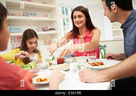 Famiglia di origine ispanica seduta a tavola a mangiare mangiare insieme Foto Stock