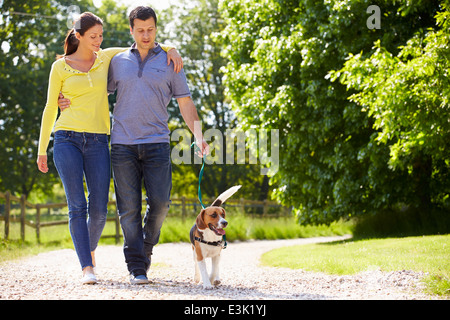 Coppia ispanica tenendo il cane per la passeggiata in campagna Foto Stock