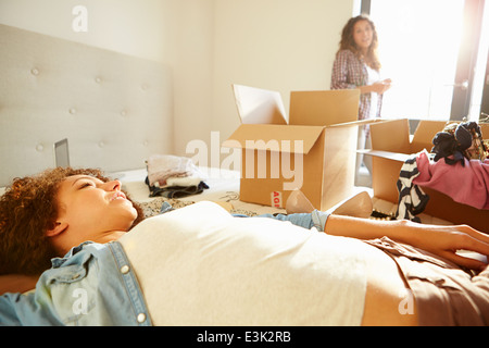 Due donne con scatole in camera da letto in movimento nella nuova casa Foto Stock